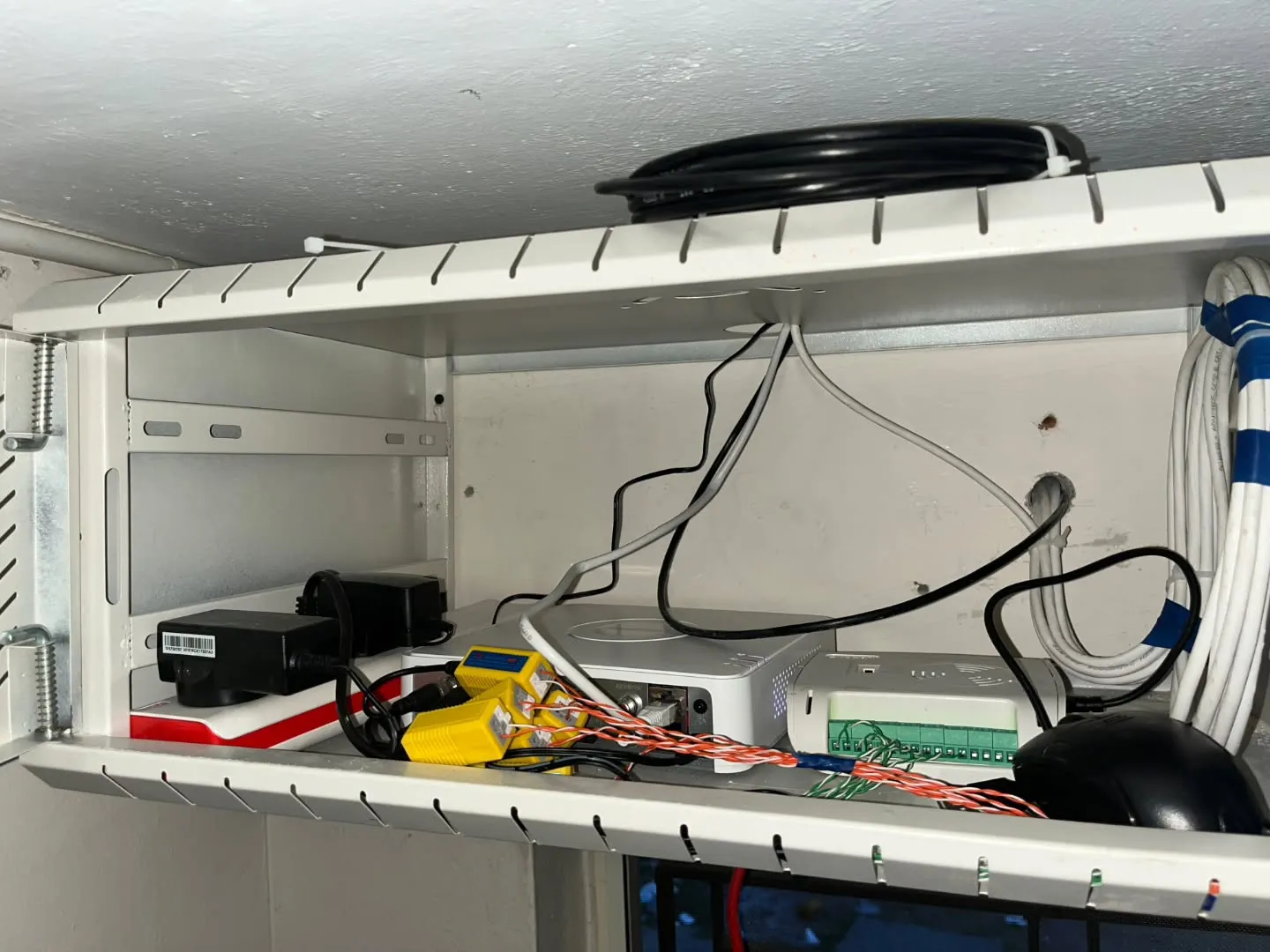 Hikvision DVR, SMPS power supply unit, and pure copper cabling neatly organized inside a white 4U wall mount server rack in Tambaram