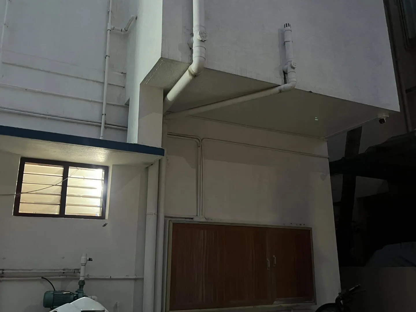 Hikvision 2MP outdoor bullet camera mounted under residential building cantilever slab with concealed weatherproof wiring