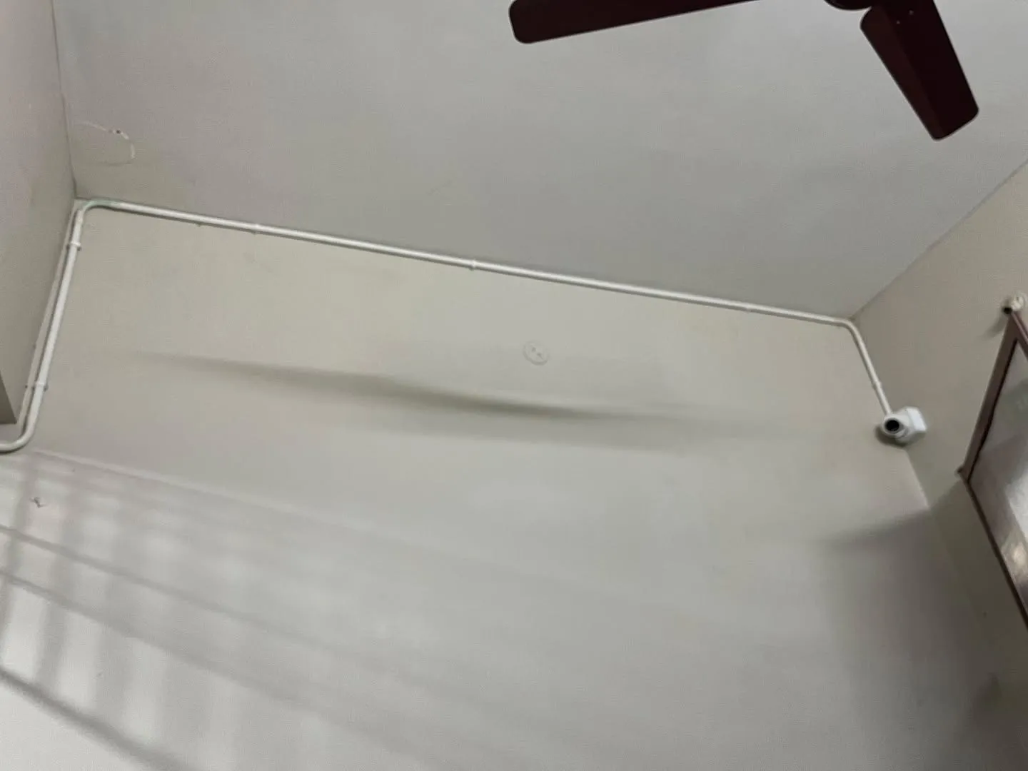 Hikvision 2MP indoor dome security camera installed on high wall with neat surface PVC conduit pipe casing along ceiling line