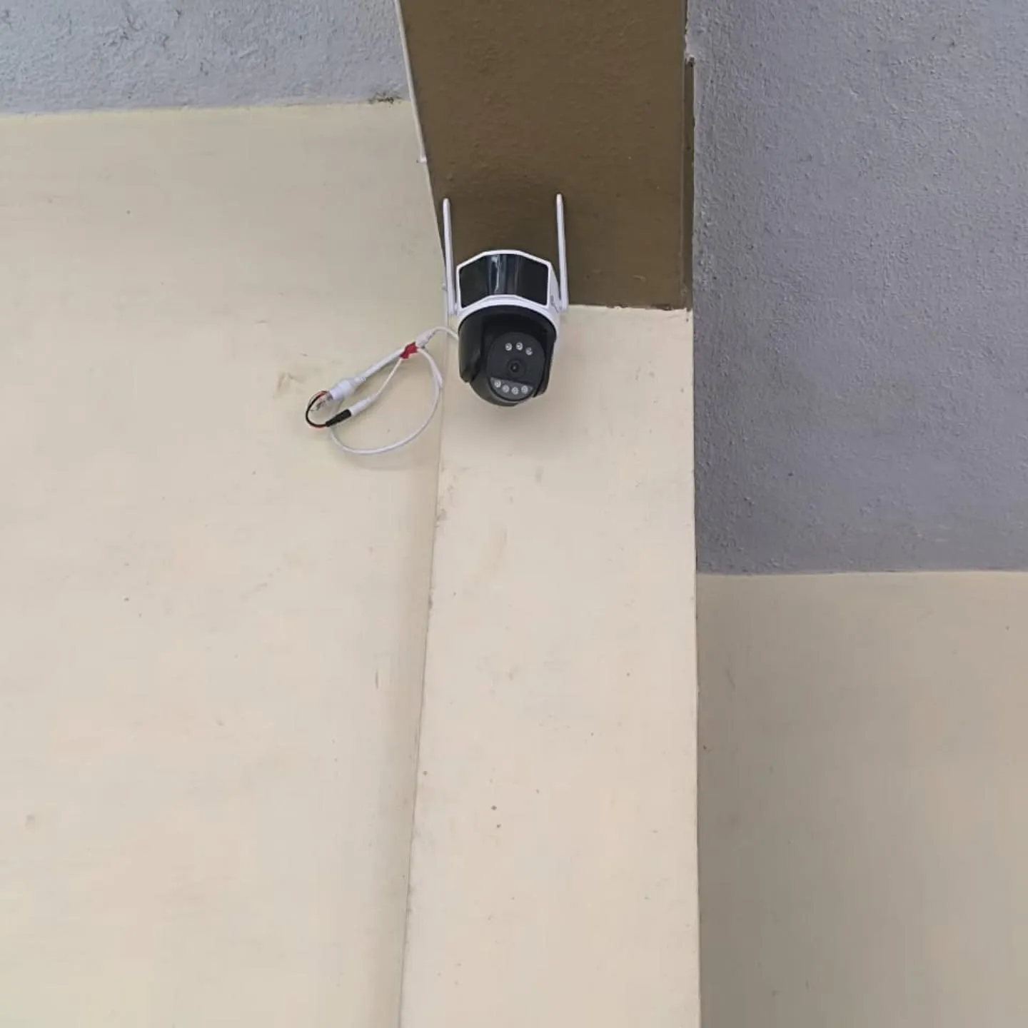 Trueview 3MP outdoor PT WiFi security camera with dual antennas mounted high on a pillar beam for residential perimeter surveillance