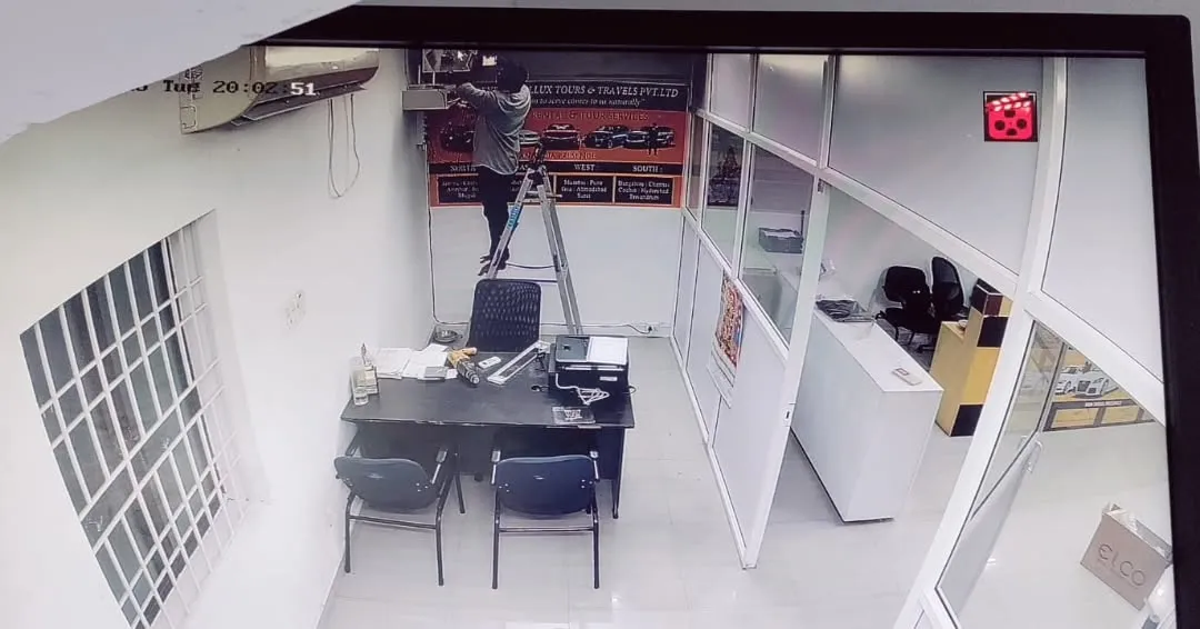 ​A security monitor displaying working of Eye Tech Securities working & displaying overhead camera feed of the internal office cubicles, workstations, and back-office partition layouts.