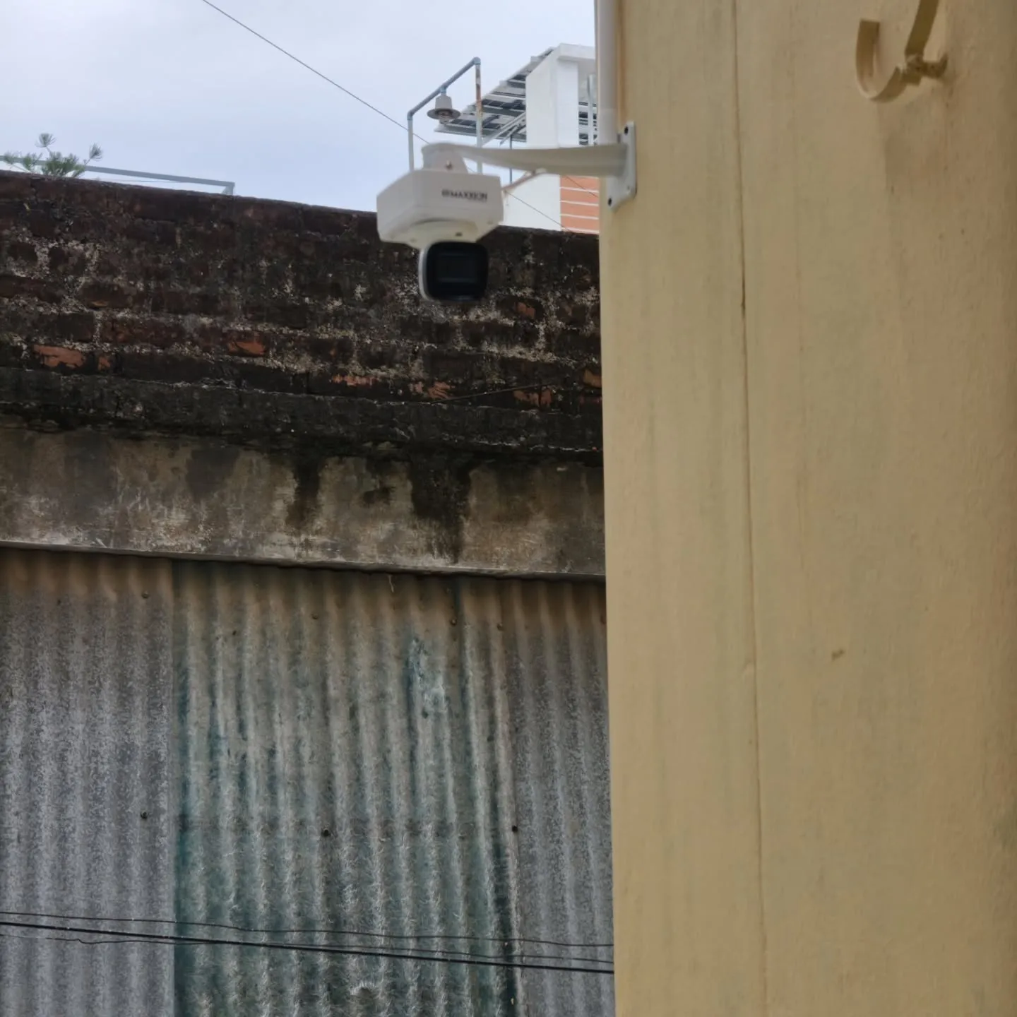 A Hikvision 5MP outdoor bullet camera mounted firmly on a dedicated camera extension stand with PVC Box to extend past the building's edge.