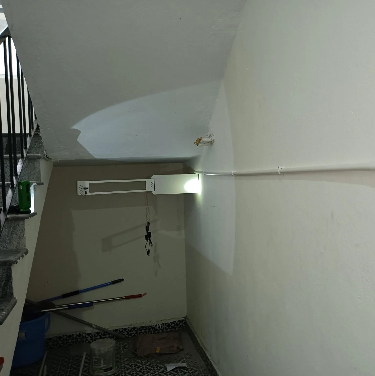 Wall mounted locked steel DVR enclosure with surface conduit wiring installed under staircase landing - View 3